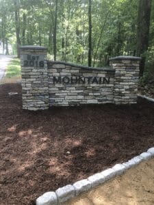 A stone sign with the word mountain in front of it.